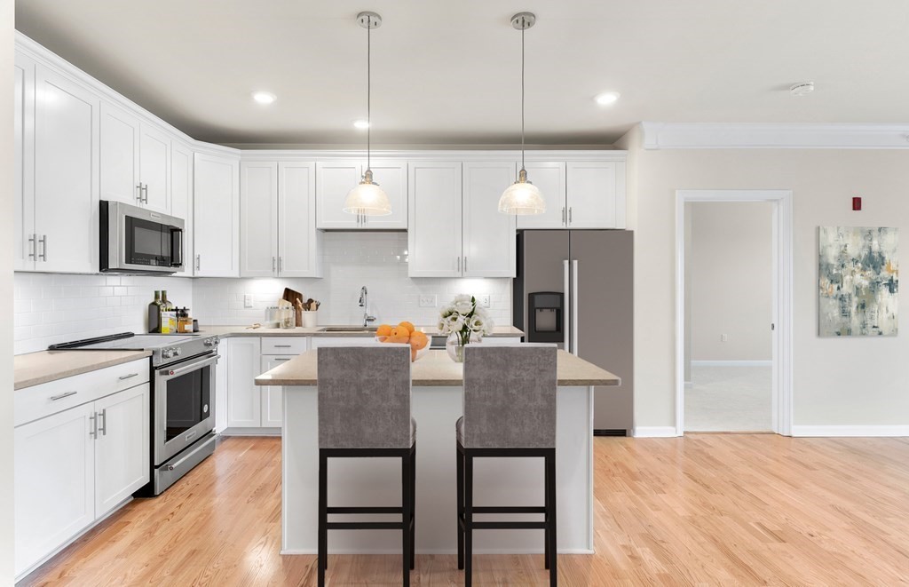 a kitchen with a table chairs refrigerator and microwave