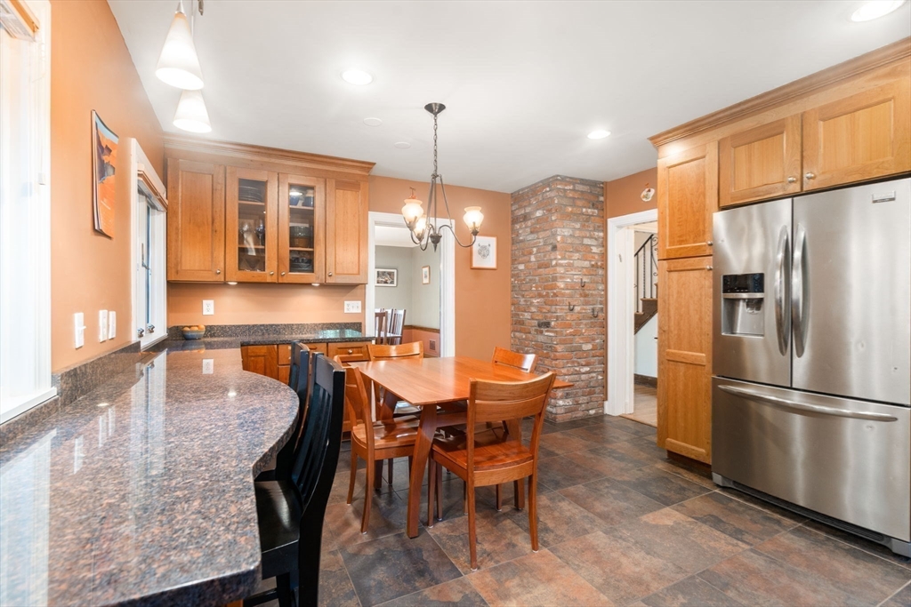 36 Blake Road Brookline, MA 02445 - Photo 15 of 34 a kitchen with stainless steel appliances granite countertop a dining table chairs refrigerator and sink