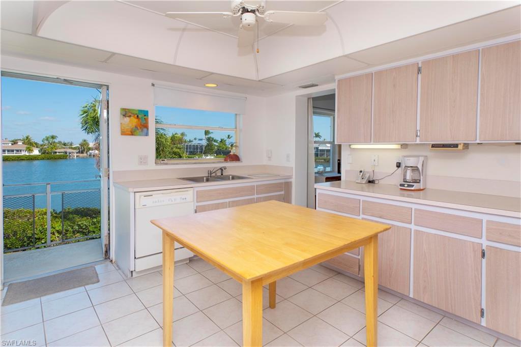 330 Kon Tiki Drive, Unit A2 Naples, FL 34113 - Photo 12 of 19 a kitchen with a sink a stove and cabinets