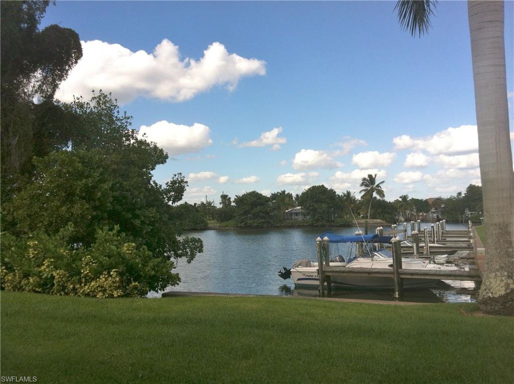 330 Kon Tiki Drive, Unit A2 Naples, FL 34113 - Photo 17 of 19 a view of a lake with table and chairs