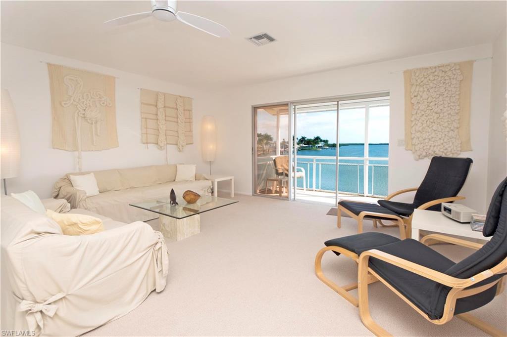 330 Kon Tiki Drive, Unit A2 Naples, FL 34113 - Photo 2 of 19 a bedroom with furniture and a large window