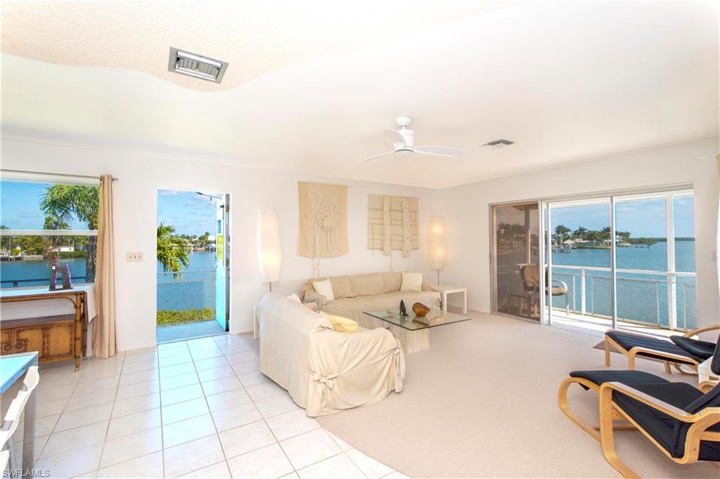 330 Kon Tiki Drive, Unit A2 Naples, FL 34113 - Photo 4 of 19 a spacious bedroom with a bed and large windows