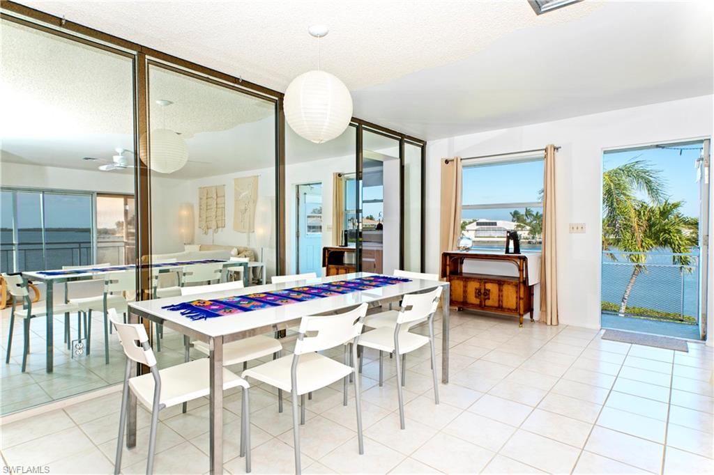 330 Kon Tiki Drive, Unit A2 Naples, FL 34113 - Photo 7 of 19 a dining room with furniture and wooden floor