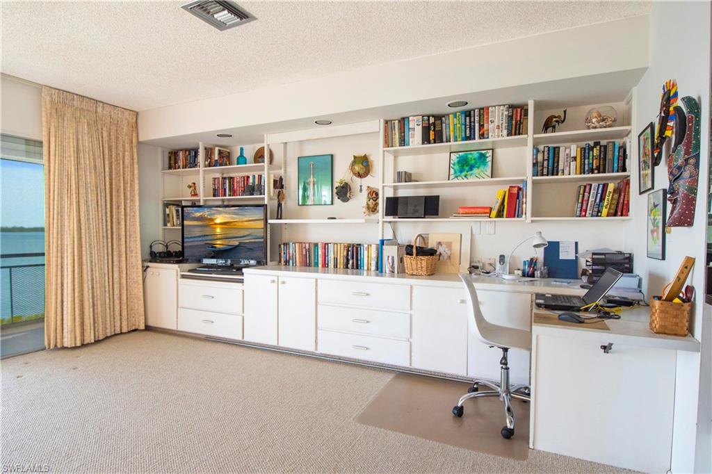 330 Kon Tiki Drive, Unit A2 Naples, FL 34113 - Photo 8 of 19 a room with furniture and a book shelf