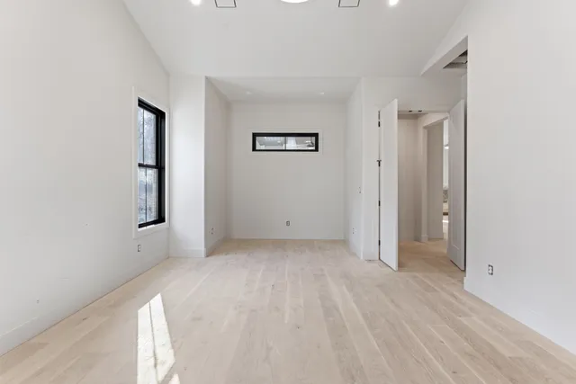 a view of an empty room with a fireplace and a window