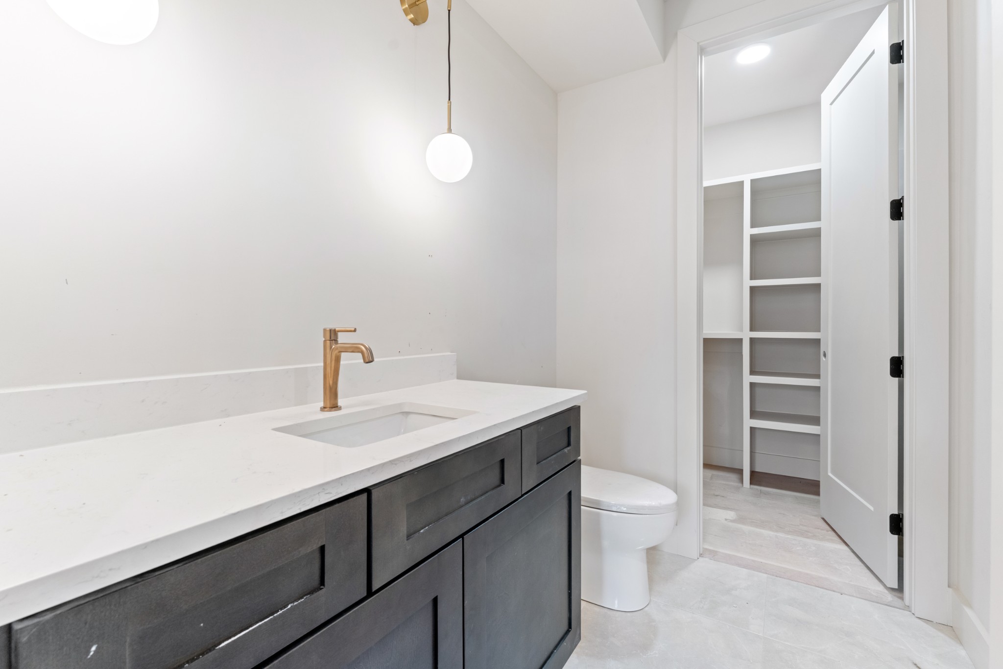 7678 Sawyer Brown Road Nashville, TN 37209 - Photo 48 of 77 a bathroom with a sink a toilet a light fixture and a vanity