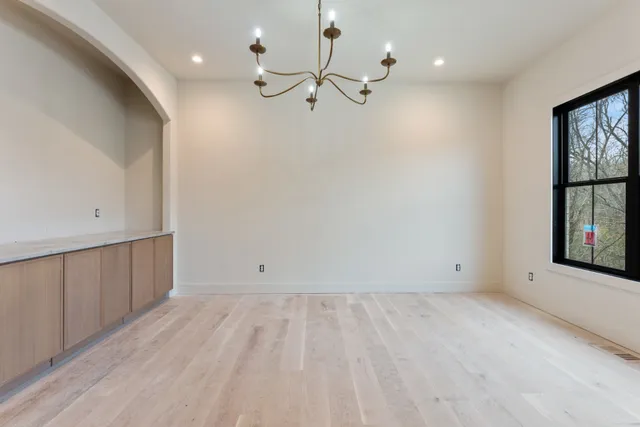 an empty room with windows and chandelier