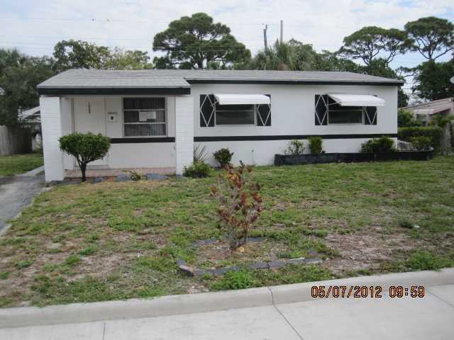 1060 West 3rd Street Riviera Beach, FL 33404 - Photo 1 of 10 a front view of a house with garden
