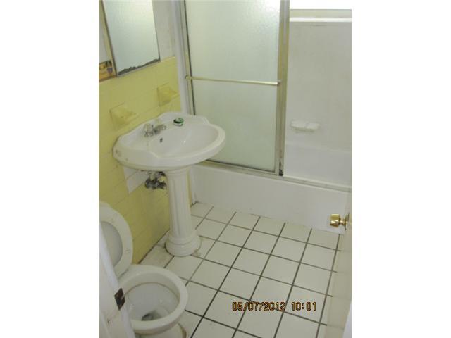 1060 West 3rd Street Riviera Beach, FL 33404 - Photo 6 of 10 a bathroom with a sink toilet and mirror