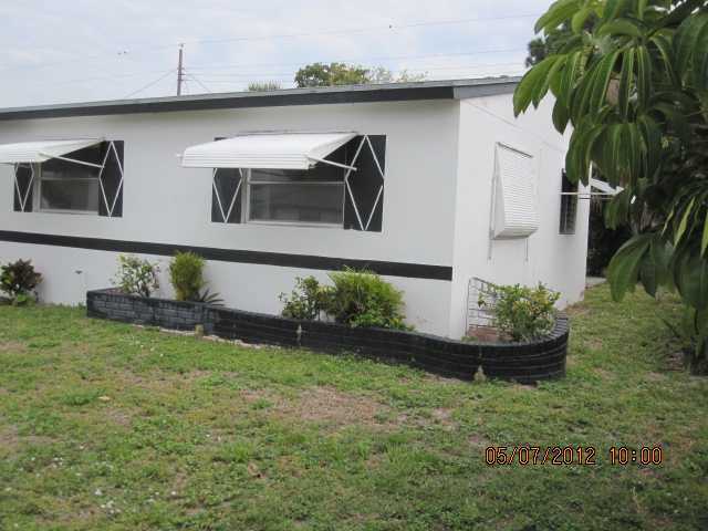 1060 West 3rd Street Riviera Beach, FL 33404 - Photo 10 of 10 a front view of a house with garden