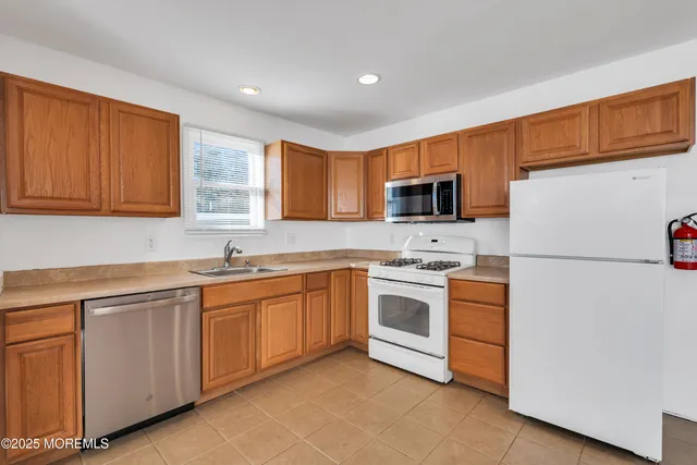 a kitchen with granite countertop stainless steel appliances a sink and a refrigerator