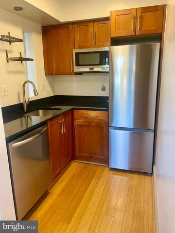 a kitchen with stainless steel appliances granite countertop a refrigerator and a sink