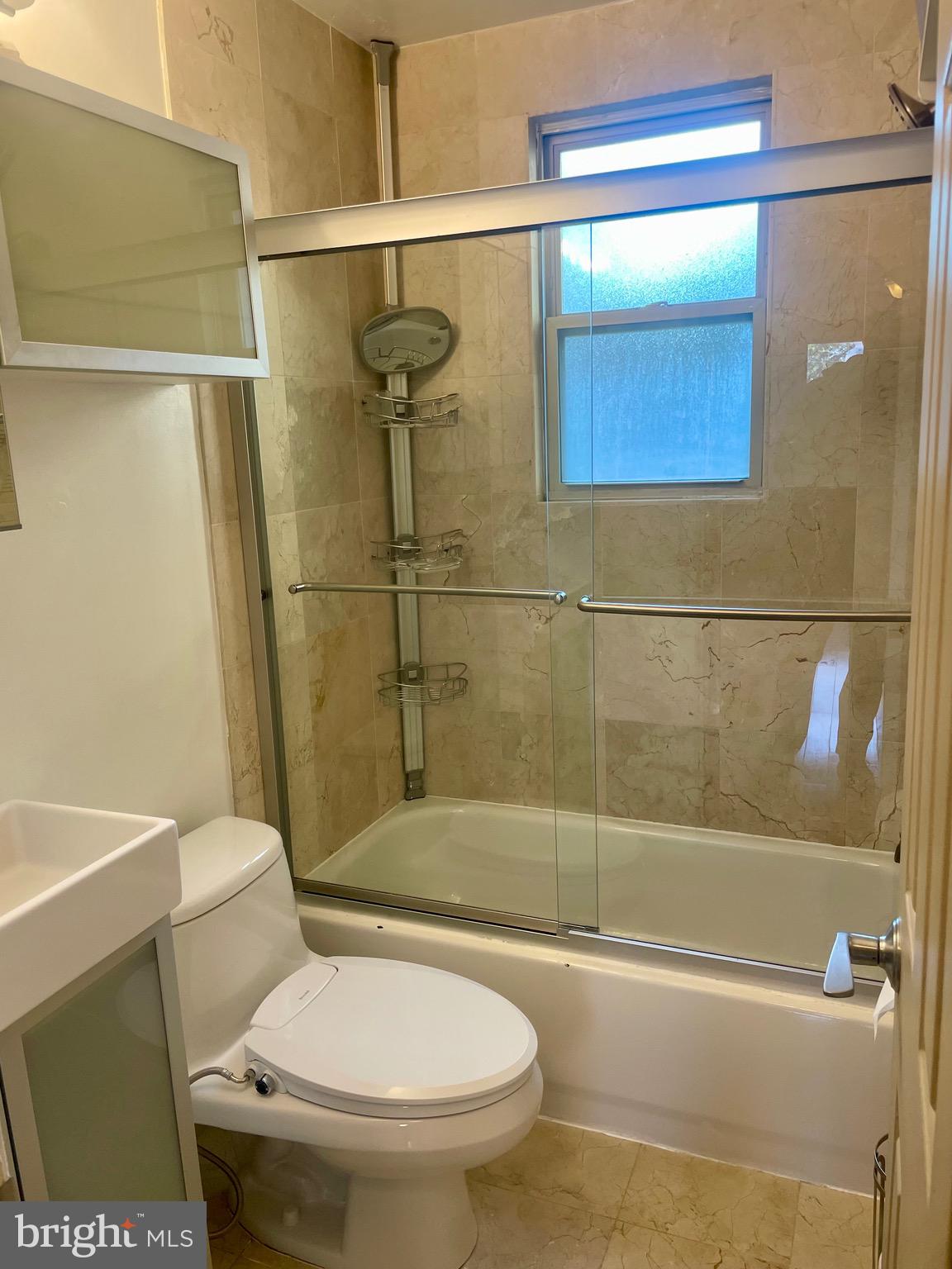 1363 K Street Southeast, Unit 103 Washington, DC 20003 - Photo 10 of 14 a white toilet sitting next to a bath tub and a shower