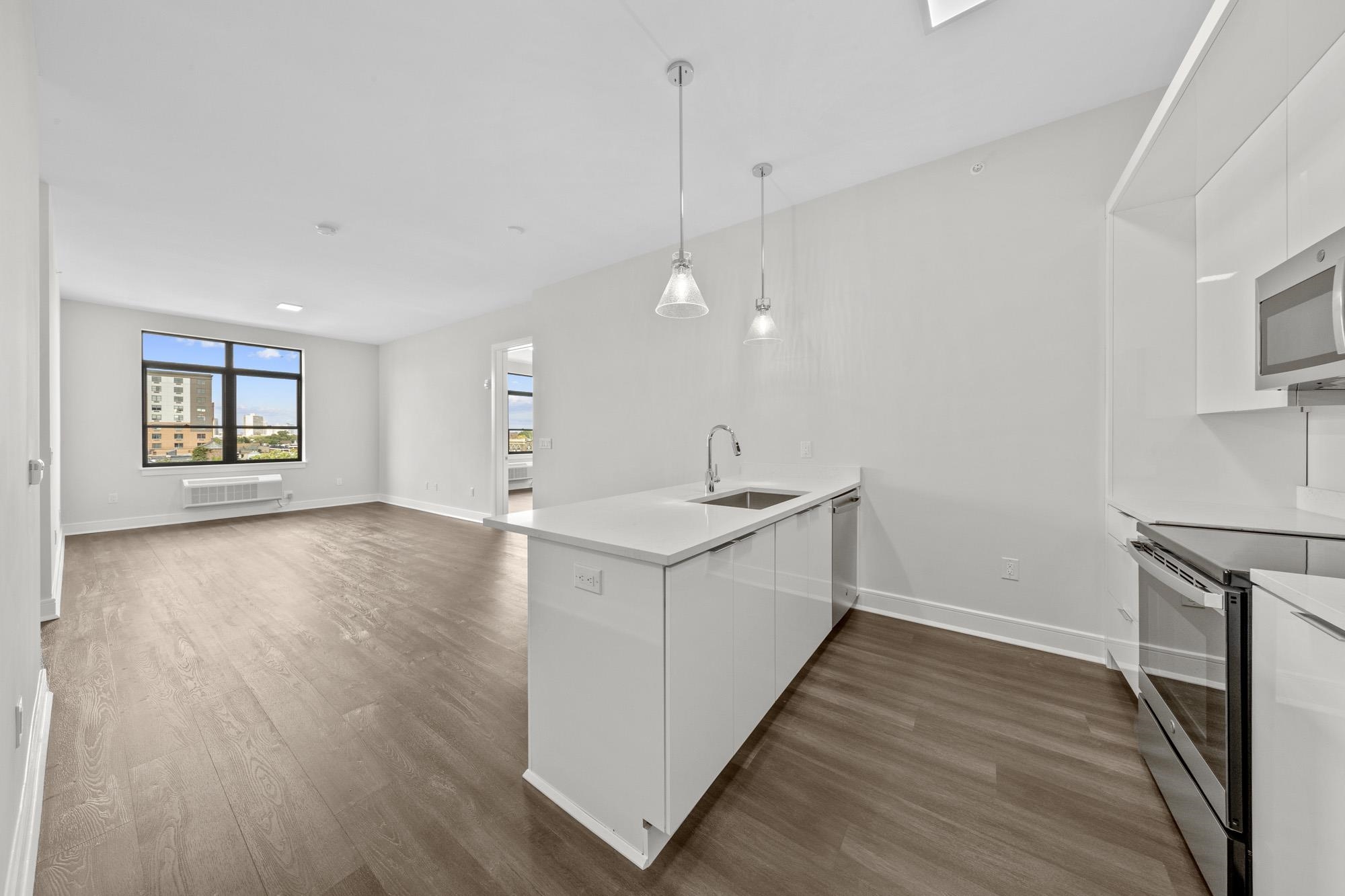 a view of a kitchen with sink and wooden floor