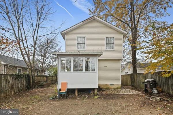 a view of a house with a yard and chairs under an umbrella