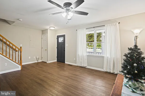 a view of an empty room with a window and a kitchen