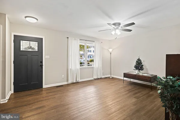 an empty room with wooden floor and ceiling fan