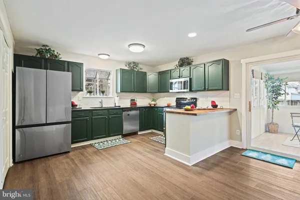 a kitchen with stainless steel appliances kitchen island granite countertop a refrigerator and a sink