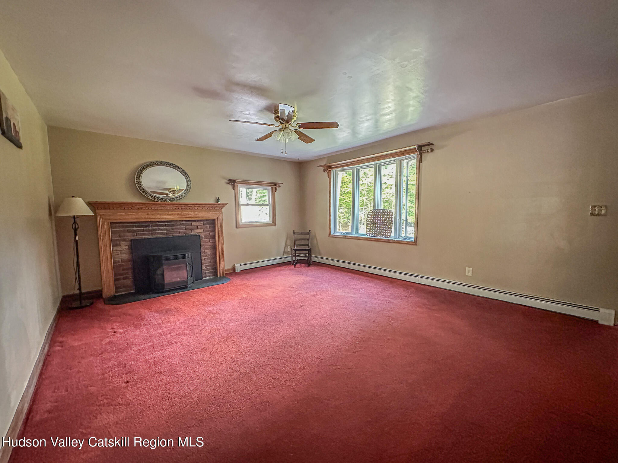 317 Scutt Road Greenville, NY 12083 - Photo 5 of 25 an empty room with windows fireplace and fan