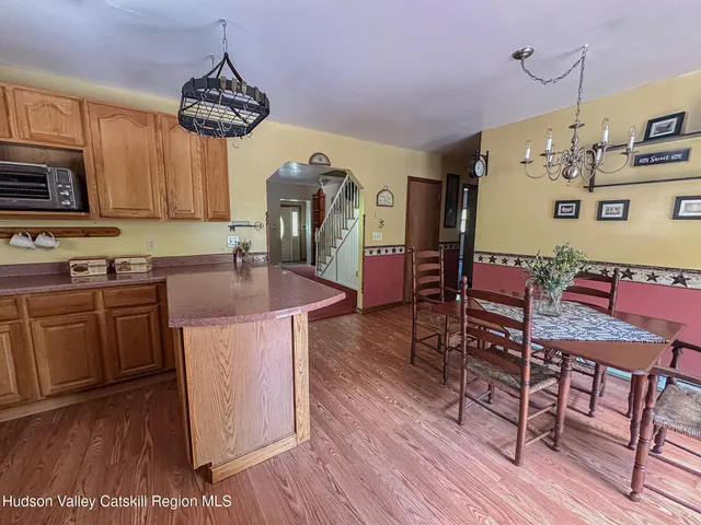 a kitchen with stainless steel appliances granite countertop a stove a sink dishwasher and a refrigerator with wooden floor