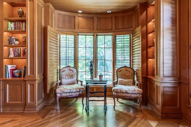 a living room with furniture a bookshelf and a window