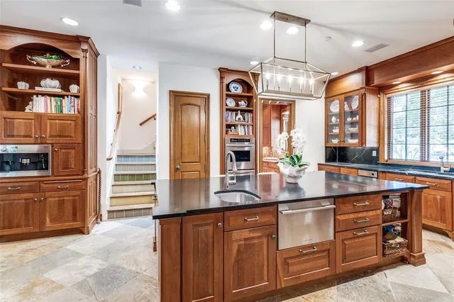a kitchen with stainless steel appliances granite countertop a sink a stove and a refrigerator