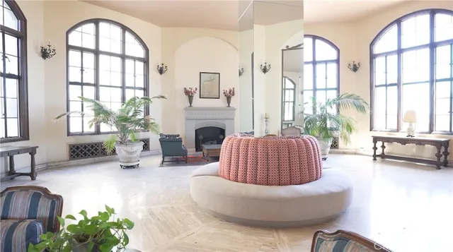 a living room with furniture fireplace and a large window