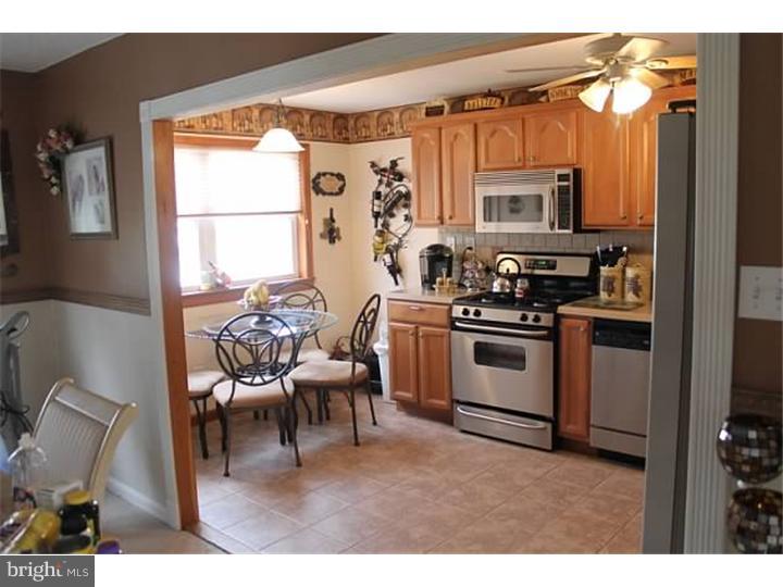 12516 Calpine Road Philadelphia, PA 19154 - Photo 6 of 22 a kitchen with stainless steel appliances a stove a sink a microwave a dining table and chairs