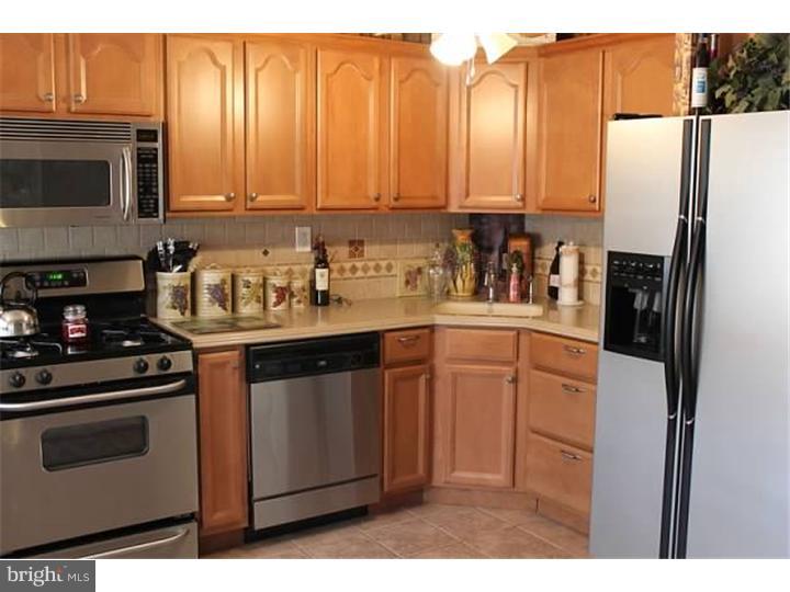 12516 Calpine Road Philadelphia, PA 19154 - Photo 8 of 22 a kitchen with stainless steel appliances a stove a microwave and a refrigerator