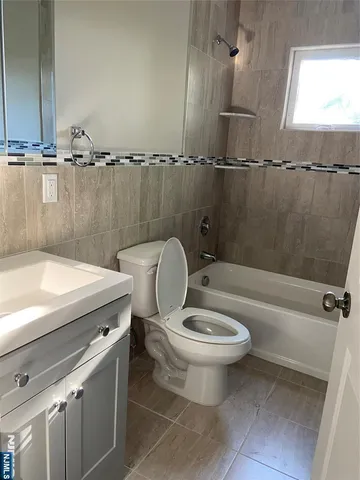 a bathroom with a granite countertop toilet a sink and bathtub