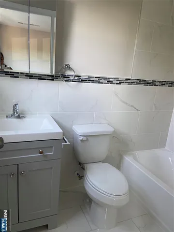 a bathroom with a sink mirror vanity and toilet