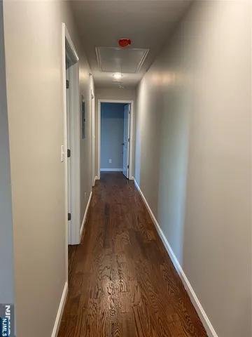 a view of a hallway with wooden floor