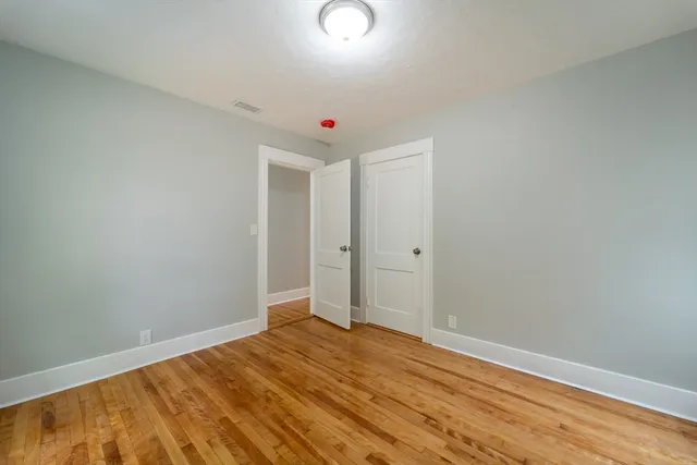 a view of a room with wooden floor and white walls
