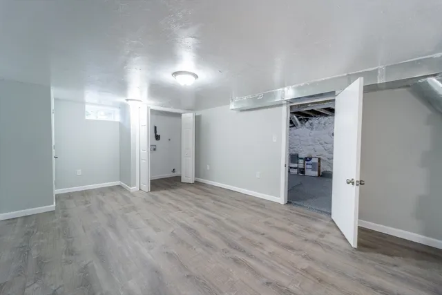 a view of empty room with wooden floor