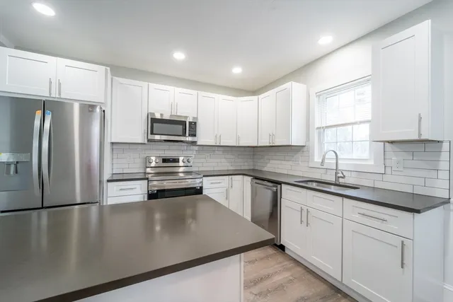 a kitchen with granite countertop a refrigerator sink and microwave