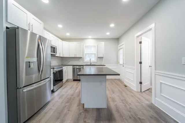 a kitchen with stainless steel appliances a refrigerator and a stove top oven