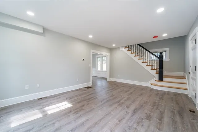 an empty room with wooden floor and entryway