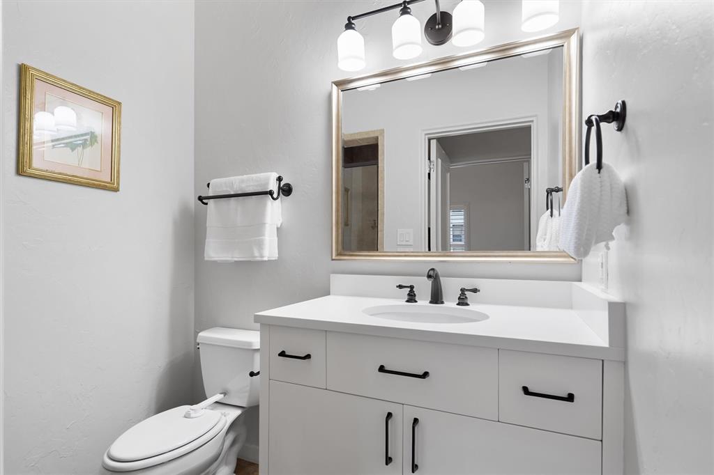 4323 Gilbert Avenue, Unit 4 Dallas, TX 75219 - Photo 26 of 40 a bathroom with a sink vanity mirror and toilet