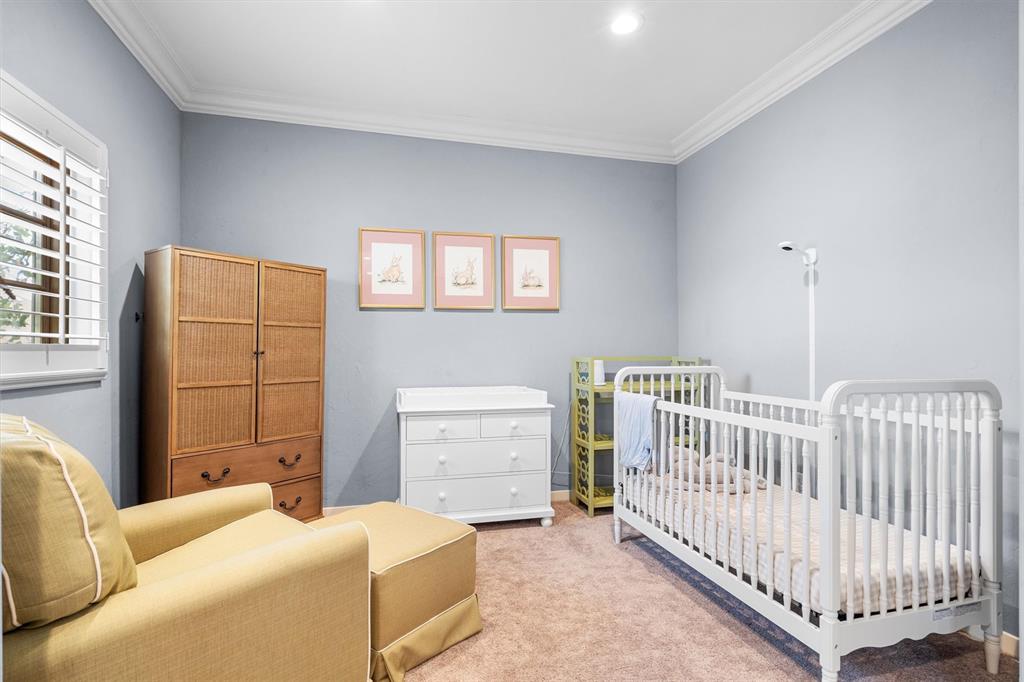 4323 Gilbert Avenue, Unit 4 Dallas, TX 75219 - Photo 34 of 40 a bedroom with furniture and baby crib