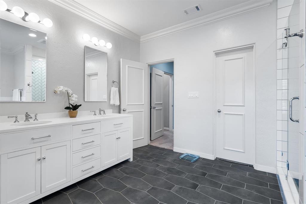 4323 Gilbert Avenue, Unit 4 Dallas, TX 75219 - Photo 36 of 40 a bathroom with a double vanity sink a mirror and a shower