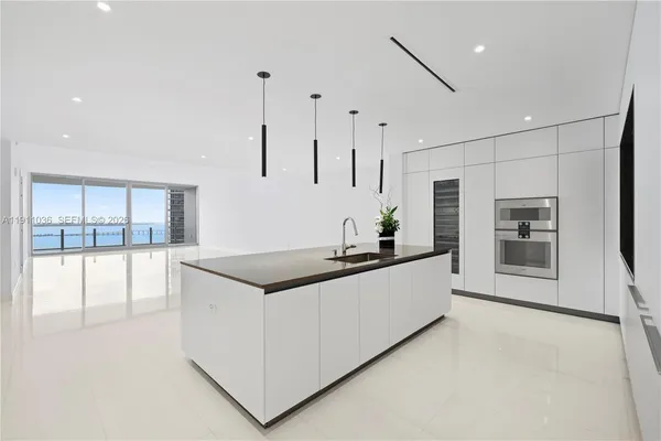 a kitchen that has a lot of cabinets in it with stainless steel appliances granite countertop a stove and a refrigerator