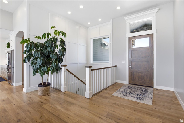 21 Pier Place Tooele, UT 84074 - Photo 6 of 112 Entryway featuring wood-finish flooring, a contemporary wooden door with glass panels, and a transom window