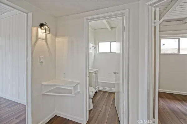 a view of a hallway with wooden floor and closet