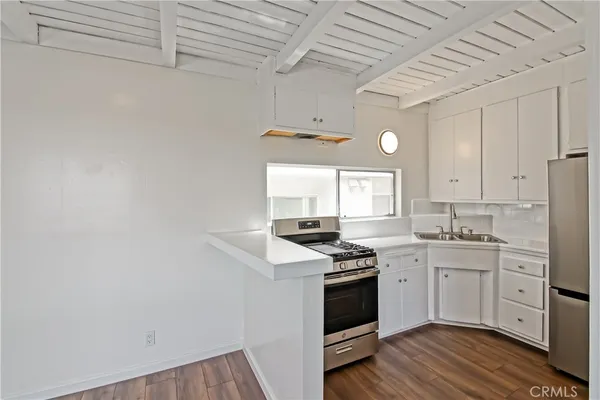 a kitchen with stainless steel appliances a white stove top oven sink and cabinets
