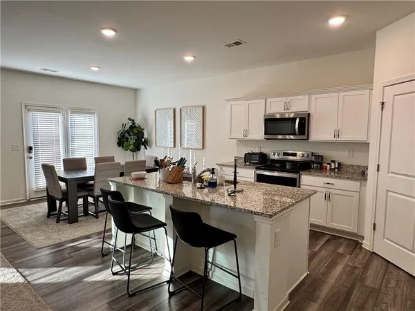 a kitchen with sink a microwave and cabinets