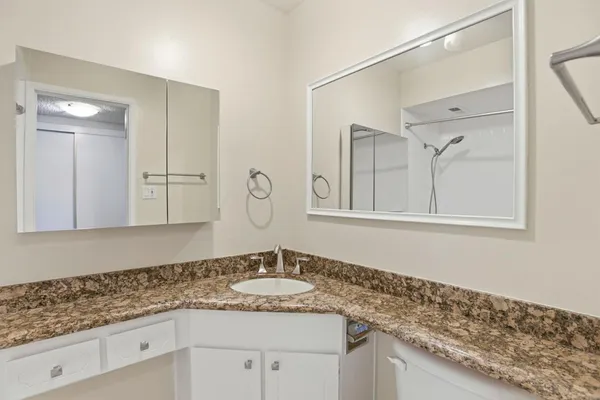 a bathroom with a granite countertop sink and a mirror