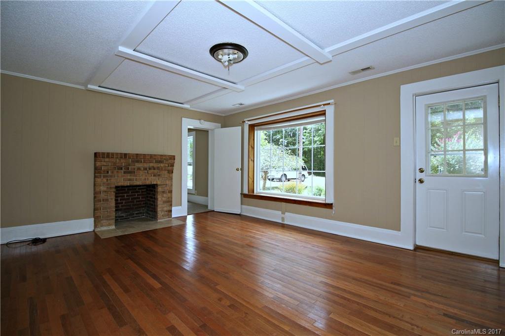 1130 Shue Road China Grove, NC 28023 - Photo 4 of 21 an empty room with wooden floor fireplace and windows
