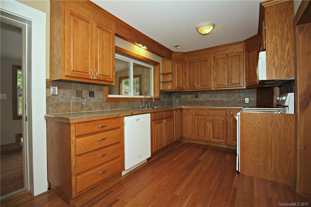 1130 Shue Road China Grove, NC 28023 - Photo 5 of 21 a kitchen with stainless steel appliances granite countertop wooden cabinets a sink and dishwasher with wooden floor