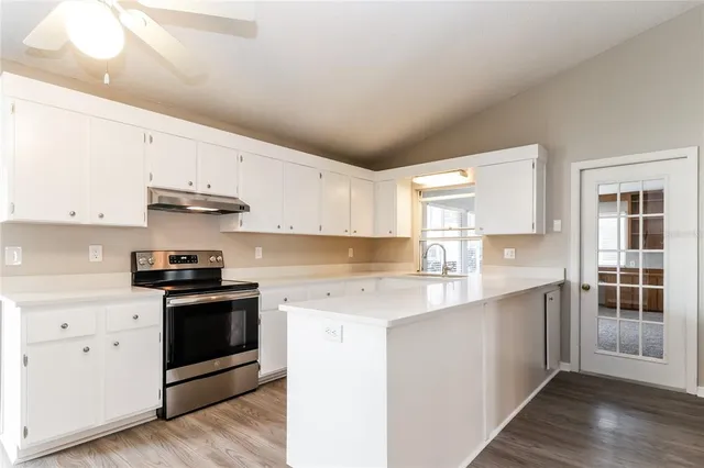 a kitchen with stainless steel appliances granite countertop a stove and white cabinets