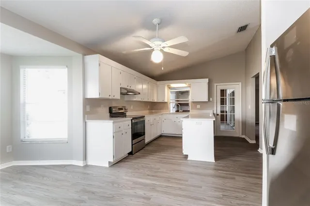 a kitchen with white cabinets and stainless steel appliances